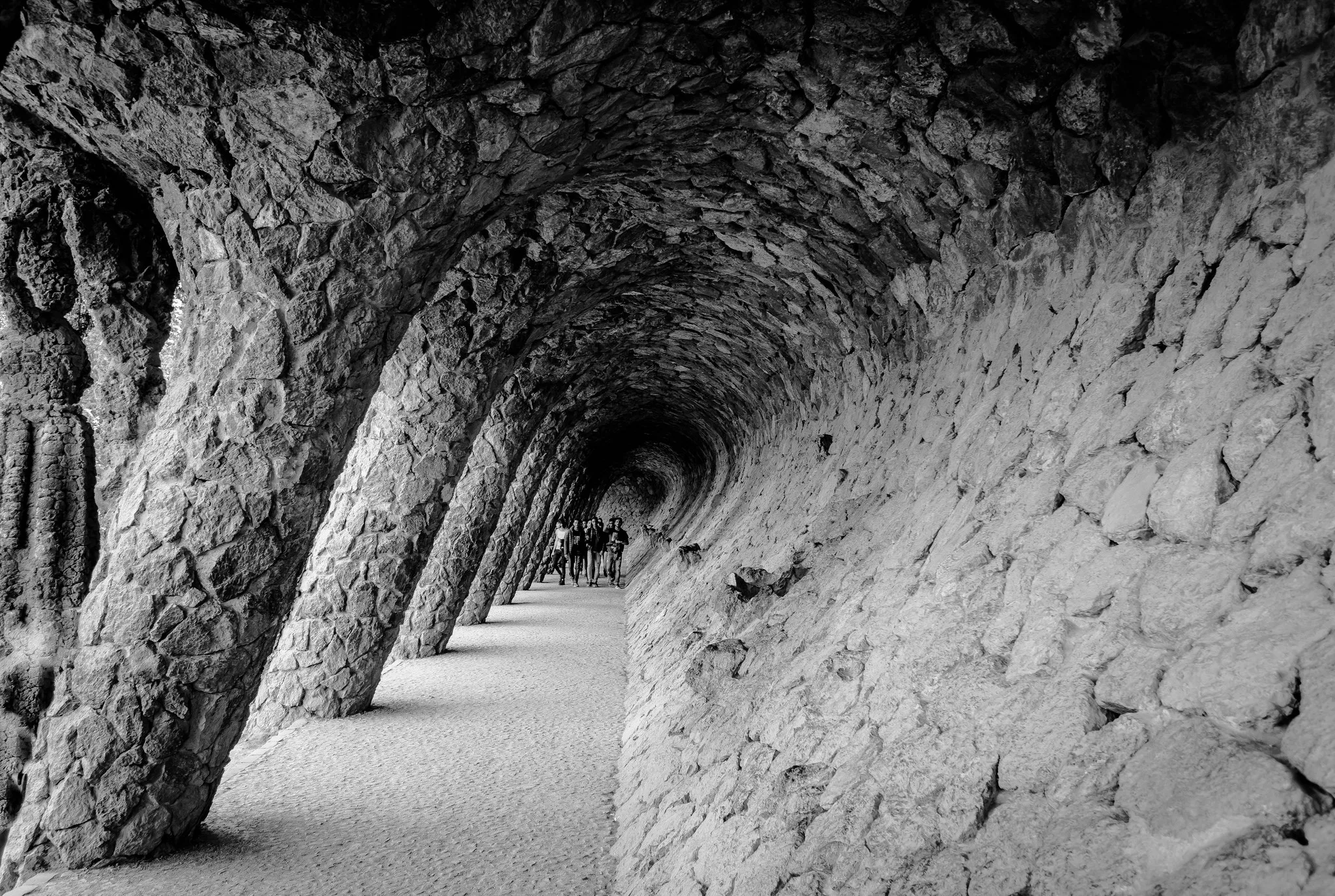 Quiet stone pathway surrounded by greenery in Park Güell